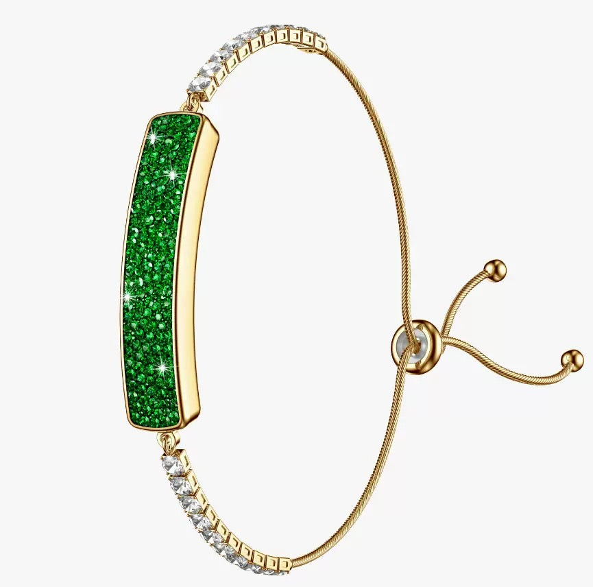 Gold-plated bangle bracelet featuring a vertical rectangular green glitter inlay, accented with clear crystal pavé settings on the top and bottom bands, shown on a plain white background.